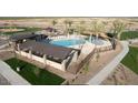 Aerial view showcasing a community pool with cabanas, lounge chairs, and manicured landscaping for relaxation and recreation at 32611 N Jasper St, San Tan Valley, AZ 85143
