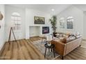 Bright living room features a cozy fireplace, wood floors, and ample natural light from large windows at 3737 E Donald Dr, Phoenix, AZ 85050