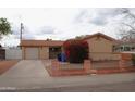 Single-story home with tan exterior, well-maintained landscaping, and an attached garage at 3822 N 48Th Dr, Phoenix, AZ 85031