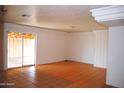 Bright living room featuring unique orange-colored tile flooring and a sliding glass door at 3822 N 48Th Dr, Phoenix, AZ 85031