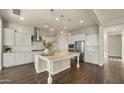 Bright, open kitchen boasts white cabinetry, a large island, stainless steel appliances, and stylish pendant lighting at 4611 E Casitas Del Rio Dr, Phoenix, AZ 85050