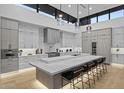 Modern kitchen with sleek cabinetry, stone countertops, an island with bar seating and modern pendant lights at 7009 E Pasadena Ave, Paradise Valley, AZ 85253