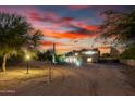 Desert home with a long driveway, desert landscaping and a dramatic sunset sky at 706 N Signal Butte Rd, Mesa, AZ 85207