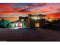 Stunning desert home featuring a vibrant red door and a picturesque sunset backdrop at 706 N Signal Butte Rd, Mesa, AZ 85207