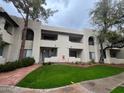 A bright two-story apartment building with red accents and landscaped entryway on a cloudy day at 750 E Northern Ave # 2085, Phoenix, AZ 85020