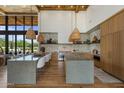 Modern kitchen with large island, stone backsplash, wooden cabinets and stylish hanging lights at 8307 E Gary Rd, Scottsdale, AZ 85260