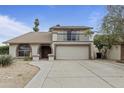 Charming two-story home featuring a balcony, arched entry, desert landscaping and a spacious driveway at 843 W Nido Ave, Mesa, AZ 85210