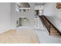 Open-concept interior showcasing architectural arches, natural lighting and stairs with wrought iron spindles at 843 W Nido Ave, Mesa, AZ 85210