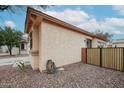 Beige stucco exterior of home showing low-maintenance landscaping and access to the backyard at 859 S Bristol --, Mesa, AZ 85208