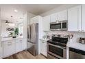 Bright kitchen featuring stainless steel appliances, white cabinetry and modern backsplash, and quartz countertops at 859 S Bristol --, Mesa, AZ 85208
