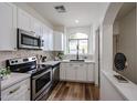 Modern kitchen features stainless steel appliances, white cabinetry, and a window over the sink at 859 S Bristol --, Mesa, AZ 85208