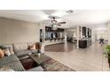 Open-concept living room showcasing a large sectional sofa, tiled floors, and access to the kitchen at 923 E Aire Libre Ave, Phoenix, AZ 85022