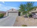 Charming single-story home with desert landscaping, a large driveway, and a two-car garage at 10300 E Trailhead Ct, Gold Canyon, AZ 85118