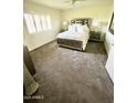 Bright bedroom features plush carpeting, a ceiling fan, and plantation shutters for a relaxing retreat at 10416 W Prairie Hills Cir, Sun City, AZ 85351