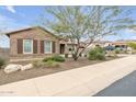 A beautifully landscaped single-story home with mature desert landscaping and a paved walkway at 10886 N 137Th St, Scottsdale, AZ 85259