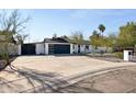 Modern home with a wide driveway and a minimalist desert landscape, enhancing its curb appeal at 13216 N 48Th Pl, Scottsdale, AZ 85254