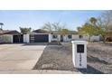 Beautiful home with a modern garage door, desert landscaping, and a welcoming address marker at 13216 N 48Th Pl, Scottsdale, AZ 85254