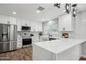 Modern kitchen with stainless steel appliances, white cabinets, and a large quartz countertop island at 13216 N 48Th Pl, Scottsdale, AZ 85254