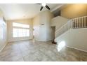 Spacious living room with tile flooring, soaring ceilings, many windows providing natural light, and a stairway at 1406 W Charleston Ave, Phoenix, AZ 85023