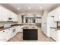 Bright kitchen with white cabinets, a black island, and an open view to the living area at 14686 W Clarendon Ave, Goodyear, AZ 85395