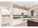 Spacious kitchen with white appliances, cabinets, and views to the laundry room at 14686 W Clarendon Ave, Goodyear, AZ 85395