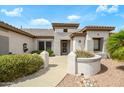 Close-up of a charming home entrance featuring desert landscaping, mature plants and a secure front door at 15750 W Linksview Dr, Surprise, AZ 85374