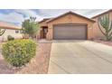 Charming home featuring low-maintenance desert landscaping and a spacious driveway leading to a two-car garage at 1814 N Parkside Ln, Casa Grande, AZ 85122