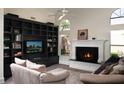 Cozy living room with a fireplace, built-in shelves, and an entertainment center perfect for relaxation and entertainment at 19219 N 88Th Way, Scottsdale, AZ 85255