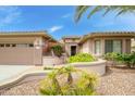 Inviting front entrance featuring a paver walkway and lush desert landscaping and covered entry at 20562 N Bear Canyon Ct, Surprise, AZ 85387