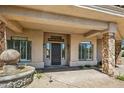 Covered entry with stone accents, manicured landscaping, and a decorative water feature at 24688 N 87Th St, Scottsdale, AZ 85255