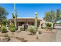 Desert home with a tile roof, native landscaping, mature saguaro cacti, and a gated front entry at 24688 N 87Th St, Scottsdale, AZ 85255