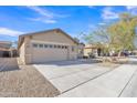 Front view of a single-story house featuring a two-car garage, driveway, and desert landscaping at 3013 W Pollack St, Phoenix, AZ 85041