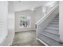 Bright and airy living room with a soaring ceiling, large window, modern ceiling fan, and staircase at 30404 N 43Rd St, Cave Creek, AZ 85331