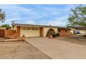 Exterior view of a single-story home featuring a two-car garage, and low maintenance desert landscaping at 3212 W Paradise Dr, Phoenix, AZ 85029