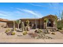 Home's exterior with desert landscaping, barrel cacti, and gravel groundcover at 34463 N 99Th Way, Scottsdale, AZ 85262