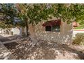 Home exterior showcases a mature tree with exposed roots, desert landscaping, and a window awning at 3535 W Monte Cristo Ave # 115, Phoenix, AZ 85053