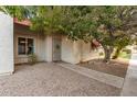 Charming home exterior with desert landscaping, a mature shade tree and a cozy, welcoming facade at 3535 W Monte Cristo Ave # 115, Phoenix, AZ 85053