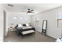 Primary bedroom features a ceiling fan, neutral carpet, and bright windows at 5811 W Encinas Ln, Phoenix, AZ 85043