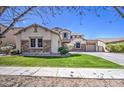 A charming home showcasing a well-manicured lawn, stone accents, and a welcoming two-story design at 6192 S Claiborne Ave, Gilbert, AZ 85298