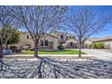 Inviting home with stone details, lush green lawn, and curb appeal enhanced by mature trees at 6192 S Claiborne Ave, Gilbert, AZ 85298