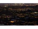 Expansive aerial view of a vibrant city at night, showcasing the illuminated skyline and residential areas at 7701 N Silvercrest Way, Paradise Valley, AZ 85253