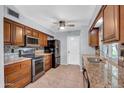 The kitchen features granite countertops, wooden cabinets, stainless steel appliances, and tiled backsplash at 9809 W Pleasant Valley Rd, Sun City, AZ 85351