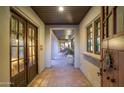 Inviting hallway featuring brick floors, arched ceilings, and beautiful wood doors at 10561 E Addy Way, Scottsdale, AZ 85262
