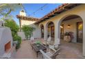 Charming outdoor patio with covered seating, stone pavers, and a lovely fireplace at 10561 E Addy Way, Scottsdale, AZ 85262