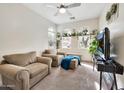 Cozy living room with plush seating, arched windows, and bright natural light at 10780 W Woodland Ave, Avondale, AZ 85323