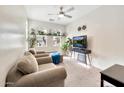 Brightly lit living area, with three plush armchairs, lots of windows, and neutral decor at 10780 W Woodland Ave, Avondale, AZ 85323