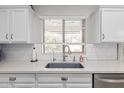Bright kitchen sink with white cabinets, sleek countertop, modern faucet, and a window with natural light at 11106 E Serafina Ave, Mesa, AZ 85212