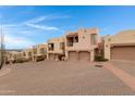 View of stucco homes, each with a two-car garage, with brick-paved driveway at 13227 N Mimosa Dr # 107, Fountain Hills, AZ 85268