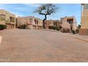 View of stucco homes and a large tree along a brick-paved driveway at 13227 N Mimosa Dr # 107, Fountain Hills, AZ 85268