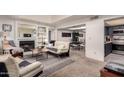 Cozy living room with a fireplace, neutral carpet, and an adjacent dining area at 1331 W Keats Ave, Mesa, AZ 85202